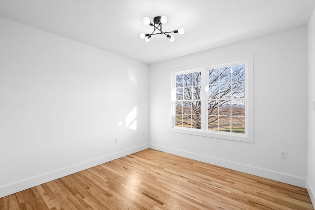 unfurnished room featuring light hardwood / wood-style floors and a chandelier