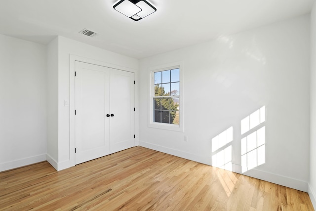 unfurnished bedroom with light hardwood / wood-style flooring and a closet