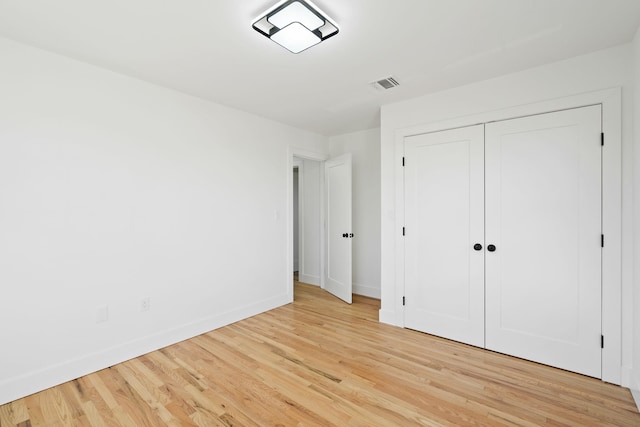 unfurnished bedroom featuring a closet and light wood-type flooring