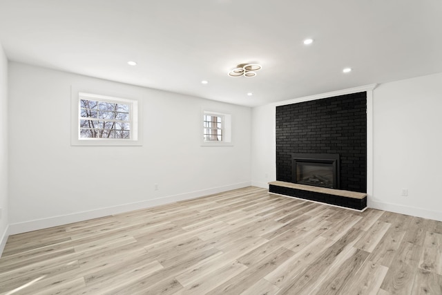 unfurnished living room featuring a fireplace and light hardwood / wood-style flooring