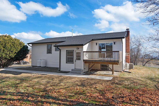 back of property featuring central air condition unit and a yard