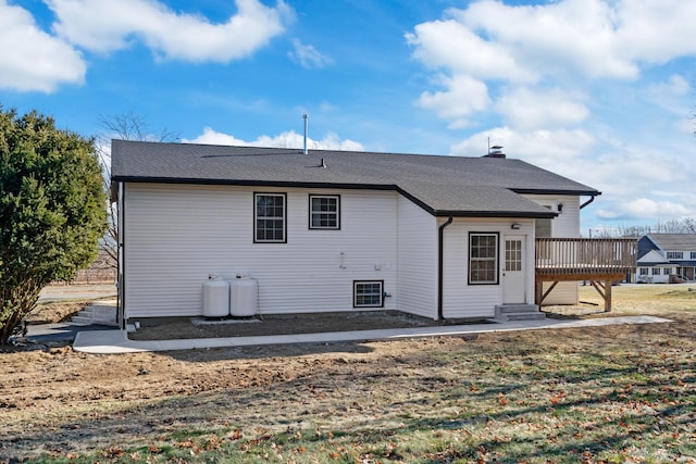 rear view of house featuring a lawn and a deck