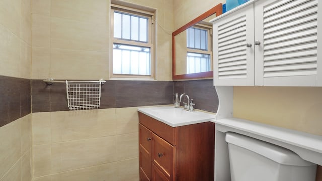 bathroom with vanity, toilet, tile walls, and backsplash