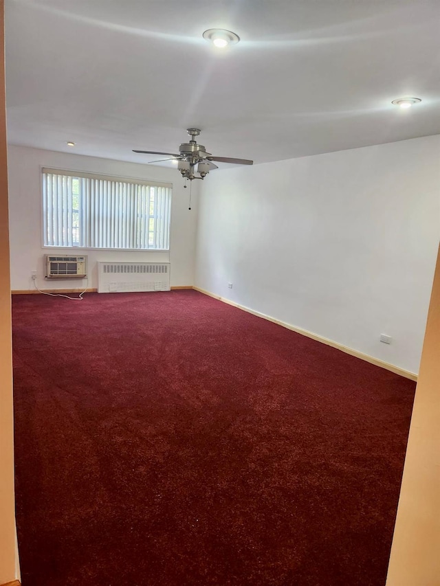 carpeted spare room featuring a wall mounted air conditioner, ceiling fan, and radiator heating unit