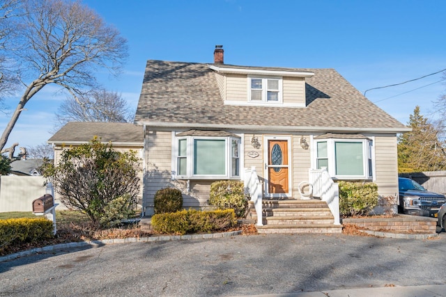 view of front of house featuring a shingled roof and a chimney