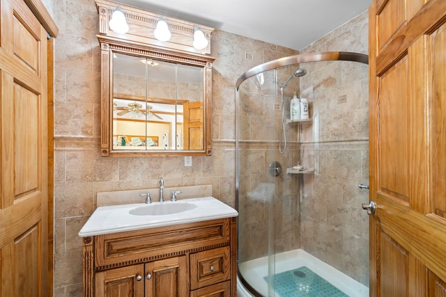 bathroom featuring a shower stall, tile walls, and vanity