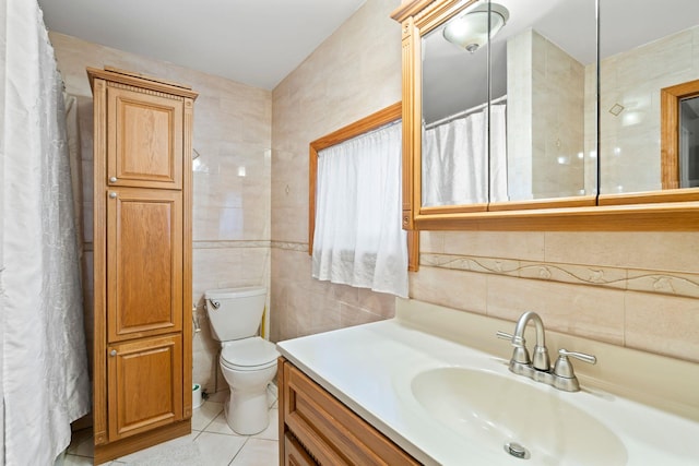 bathroom with toilet, vanity, tile walls, and tile patterned floors