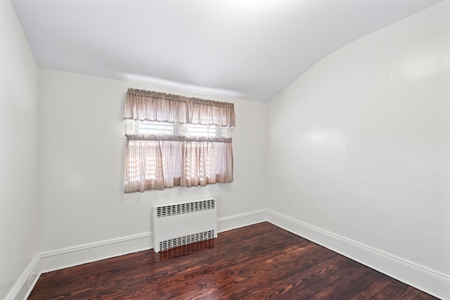 unfurnished room with radiator heating unit, baseboards, and wood finished floors