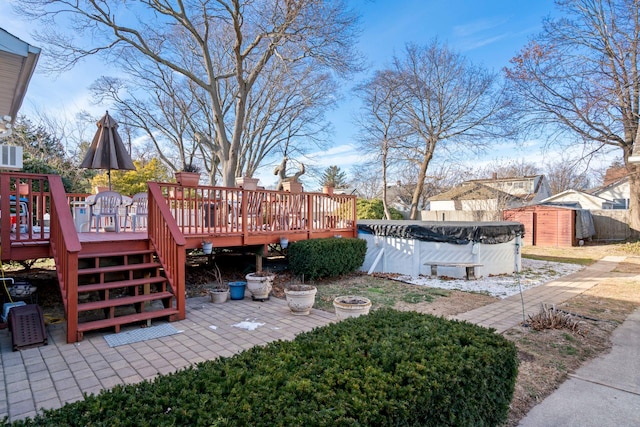 view of yard featuring a fenced in pool, an outdoor structure, a wooden deck, and a shed