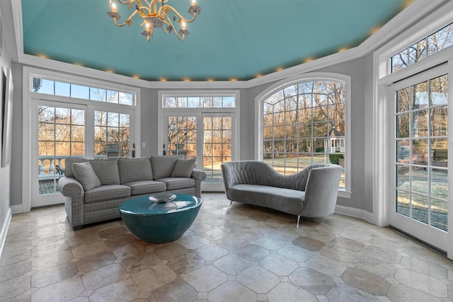 sunroom / solarium featuring a healthy amount of sunlight and a notable chandelier