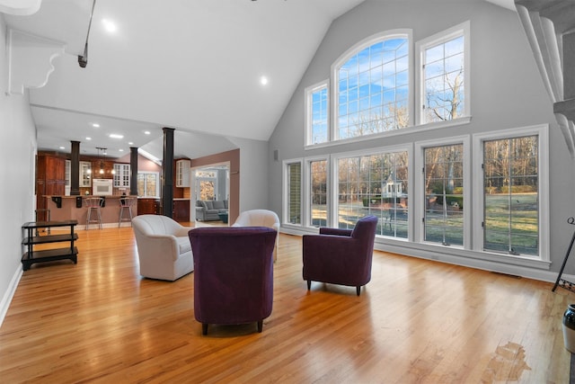 living room with high vaulted ceiling and light wood-type flooring