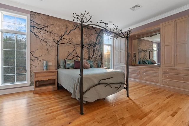 bedroom featuring crown molding and light hardwood / wood-style flooring