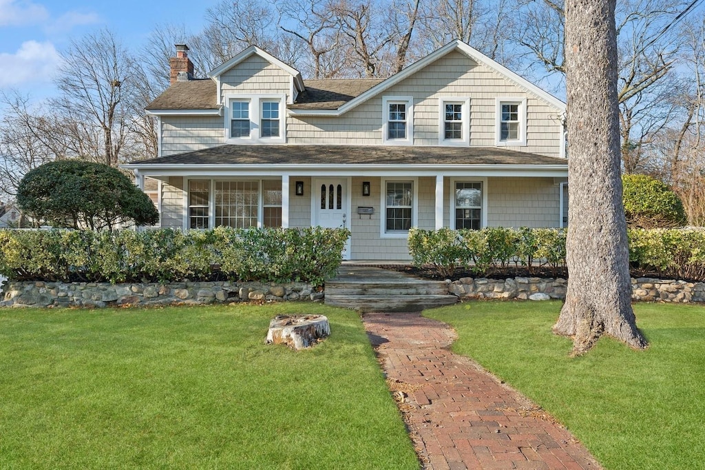 view of front of home with a porch and a front lawn