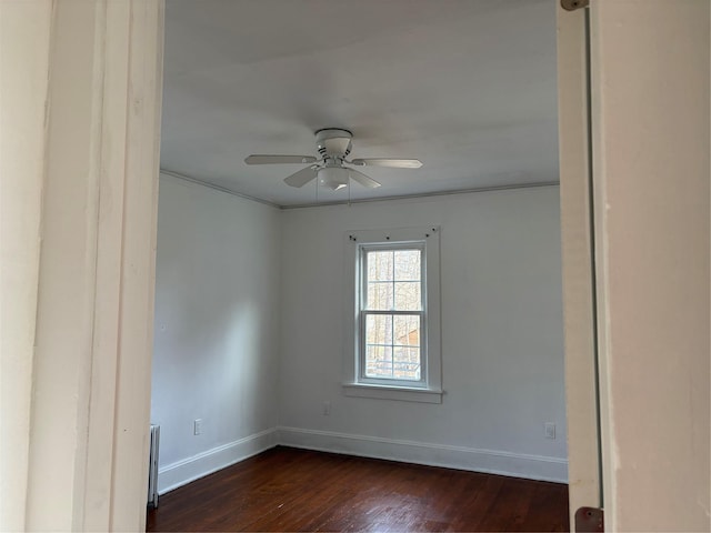 spare room featuring dark hardwood / wood-style flooring, ceiling fan, and crown molding