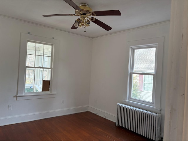 spare room with ceiling fan, dark hardwood / wood-style flooring, ornamental molding, and radiator