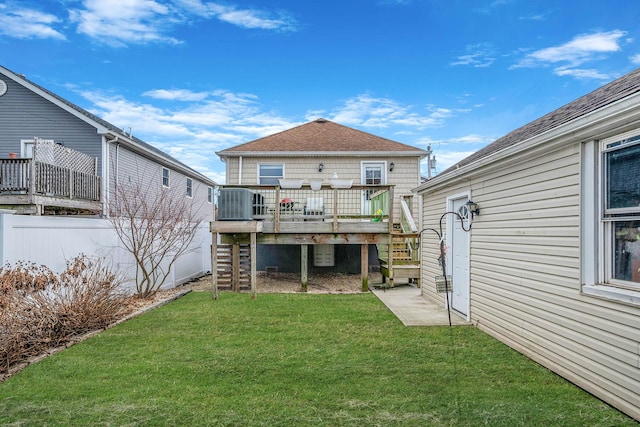 rear view of house featuring central AC unit, a yard, and a deck