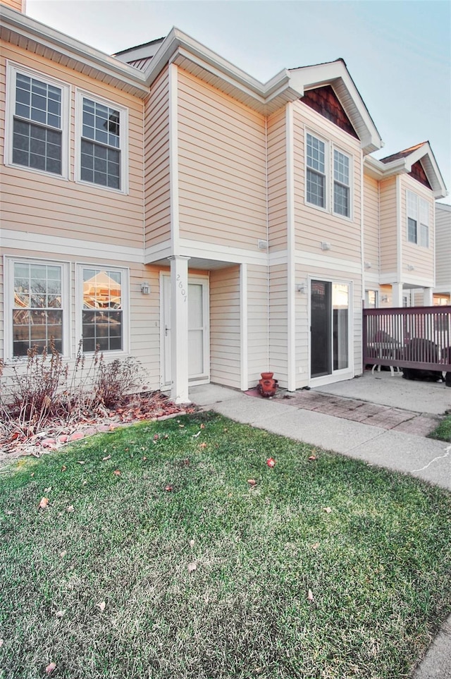 townhome / multi-family property featuring a patio area, a front lawn, and a deck