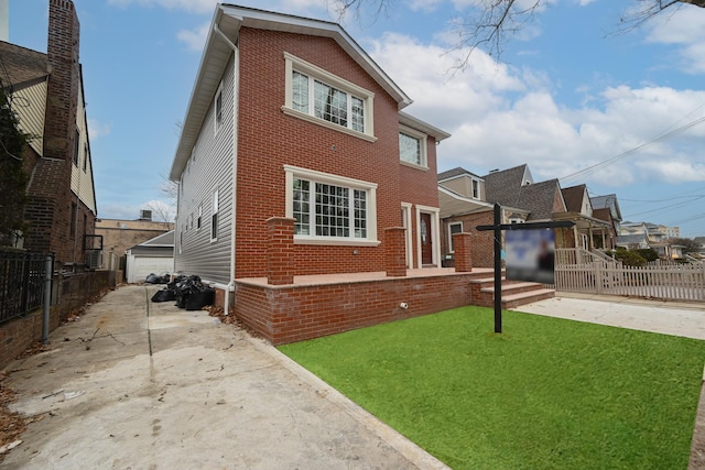 view of front of home featuring a front yard, a garage, and an outdoor structure