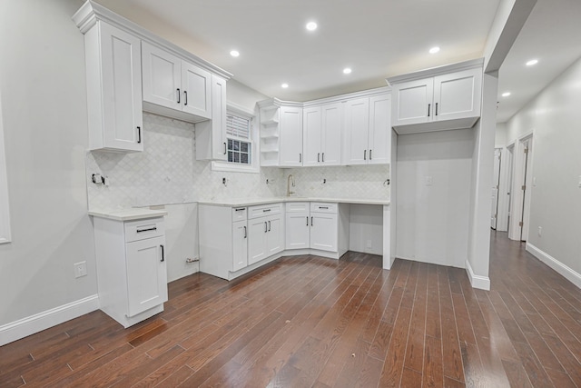 kitchen with dark hardwood / wood-style flooring, white cabinetry, and backsplash