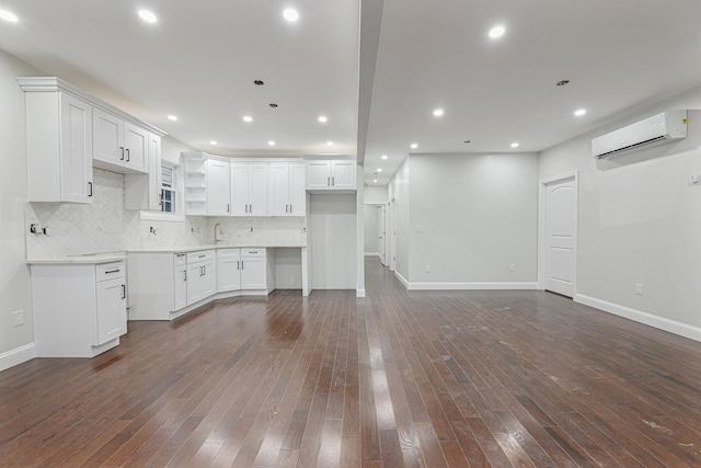 kitchen with a wall mounted air conditioner, dark hardwood / wood-style floors, white cabinets, and decorative backsplash