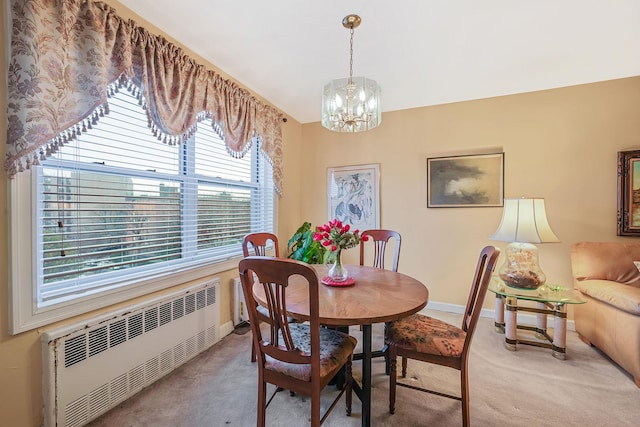 carpeted dining space with a chandelier and radiator heating unit