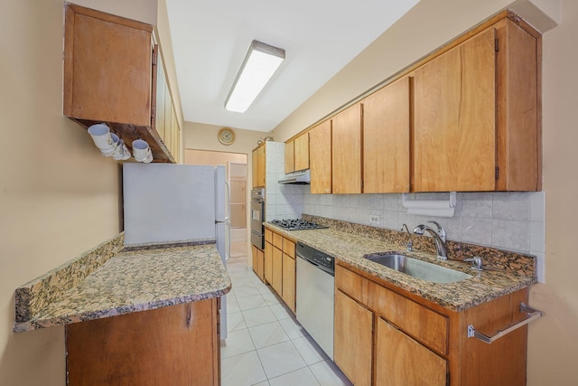 kitchen with light tile patterned flooring, decorative backsplash, stainless steel appliances, and sink