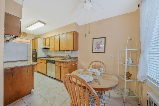 kitchen featuring ceiling fan, sink, stainless steel appliances, backsplash, and light tile patterned floors