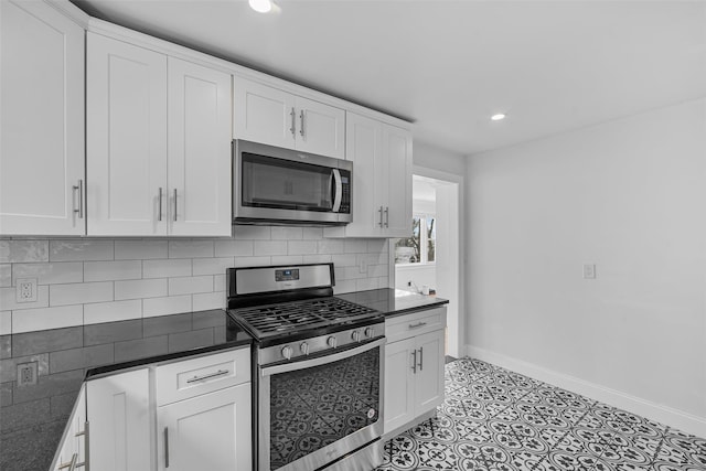 kitchen featuring stainless steel appliances, white cabinetry, and tasteful backsplash