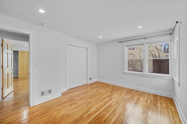 unfurnished bedroom with a closet and light wood-type flooring