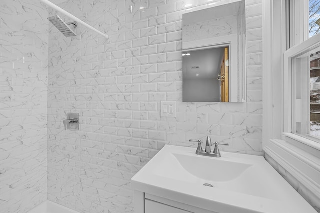 bathroom featuring tiled shower and vanity