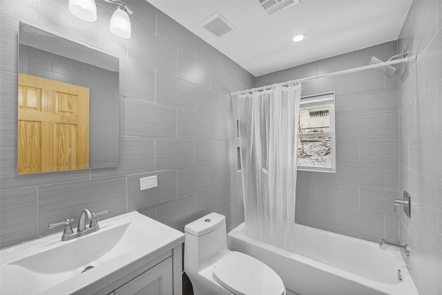 full bathroom featuring vanity, toilet, tile walls, and shower / tub combo