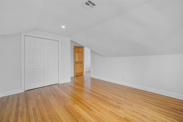 bonus room with vaulted ceiling and light wood-type flooring