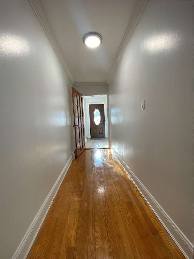 corridor featuring wood-type flooring, french doors, and crown molding