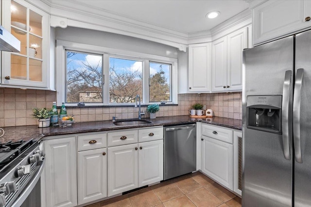 kitchen featuring dark stone counters, sink, light tile patterned floors, white cabinetry, and stainless steel appliances