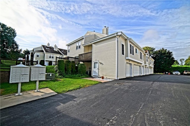 view of home's exterior featuring mail boxes, a garage, and a yard