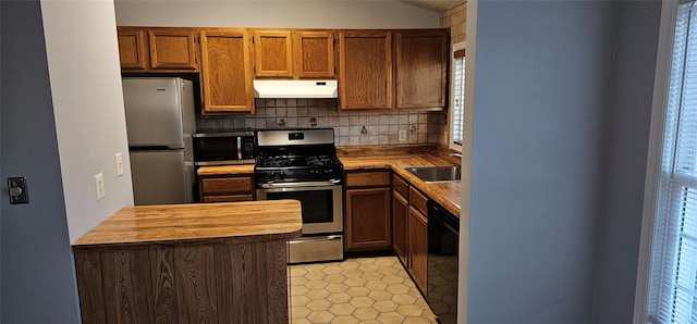 kitchen with butcher block countertops, decorative backsplash, sink, and appliances with stainless steel finishes