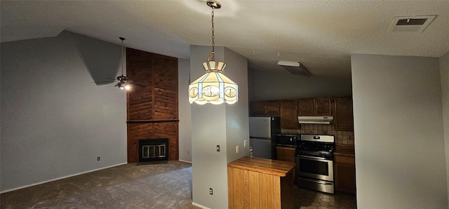 kitchen featuring lofted ceiling, ceiling fan, decorative backsplash, appliances with stainless steel finishes, and a large fireplace