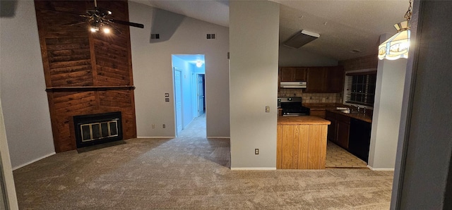 kitchen featuring gas stove, sink, a large fireplace, tasteful backsplash, and light colored carpet