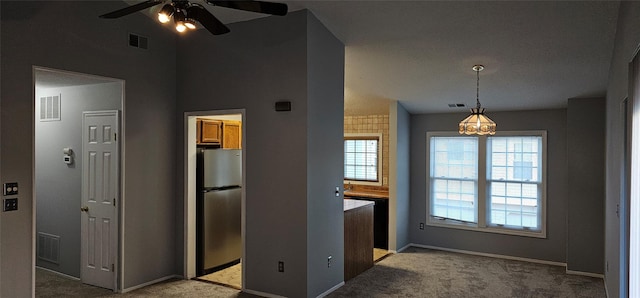 kitchen featuring ceiling fan, light colored carpet, decorative light fixtures, and stainless steel refrigerator