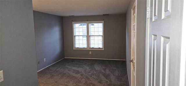 carpeted spare room featuring a textured ceiling