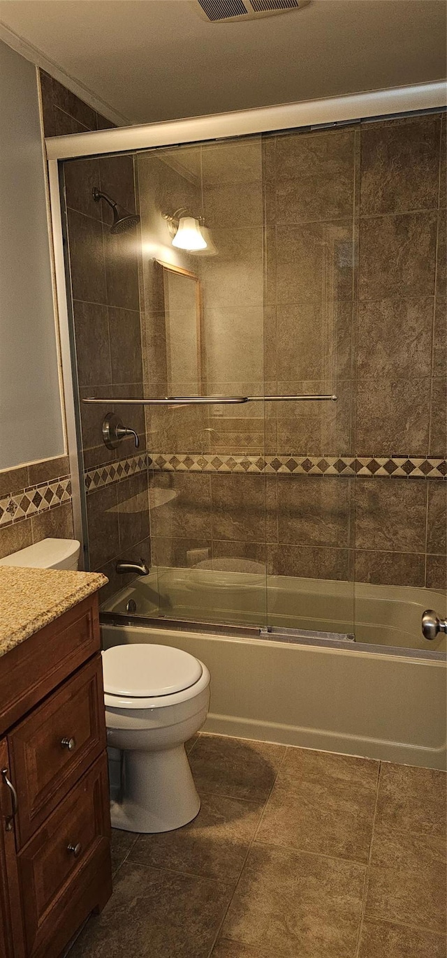 full bathroom with vanity, tile patterned flooring, toilet, enclosed tub / shower combo, and tile walls