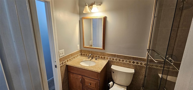 bathroom featuring walk in shower, vanity, tile walls, and toilet