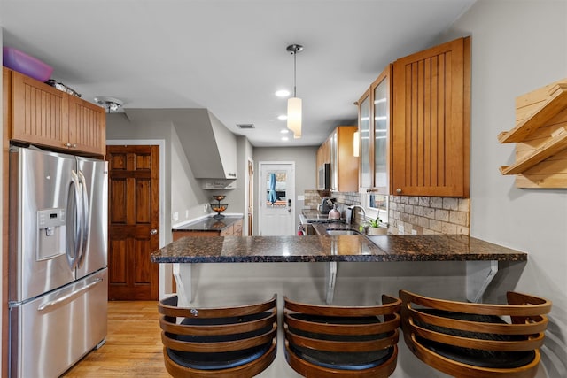 kitchen with stainless steel appliances, a breakfast bar area, kitchen peninsula, and pendant lighting