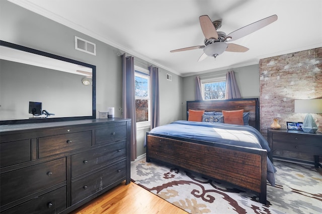 bedroom featuring ornamental molding, light wood-type flooring, and ceiling fan