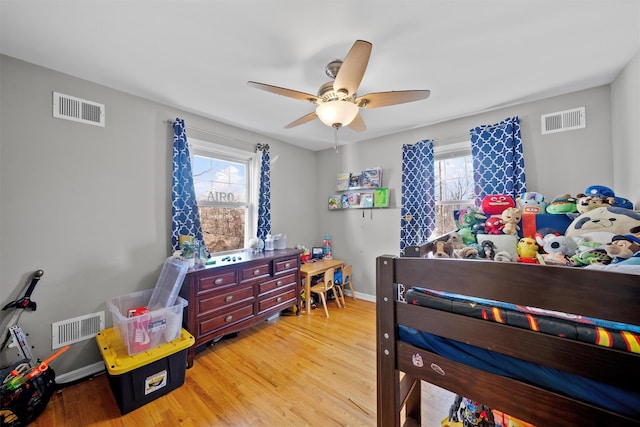 bedroom featuring multiple windows, ceiling fan, and light hardwood / wood-style floors