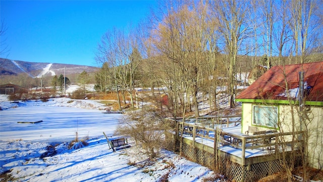 yard covered in snow with a deck with mountain view