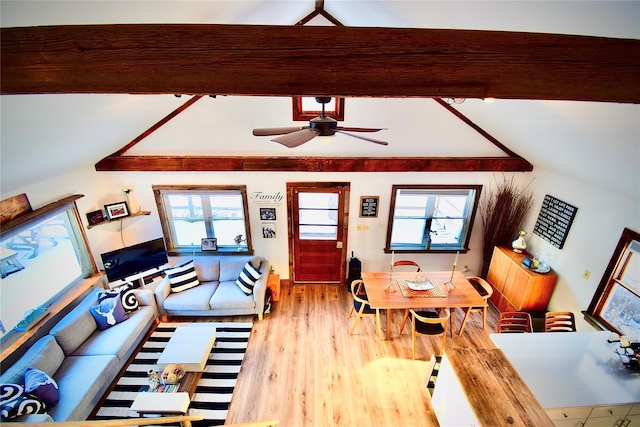 living room featuring vaulted ceiling with beams, a healthy amount of sunlight, and hardwood / wood-style flooring