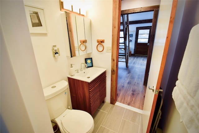 bathroom with hardwood / wood-style floors, vanity, and toilet