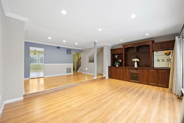 unfurnished living room featuring light hardwood / wood-style floors and ornamental molding