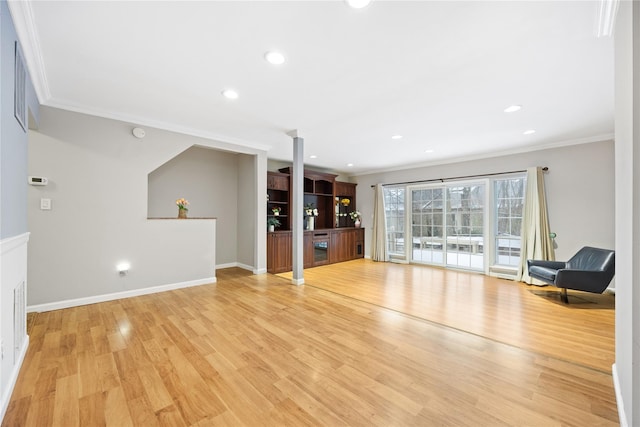 unfurnished living room with crown molding and light hardwood / wood-style floors